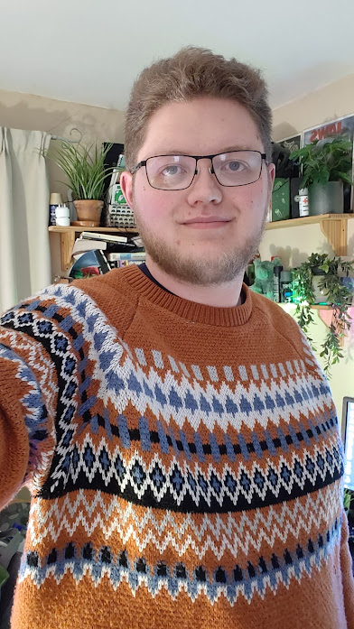 Andrew in a patterned orange jumper, inside